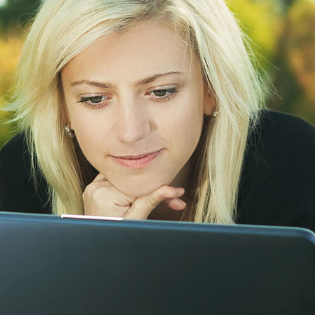 woman on computer in grass