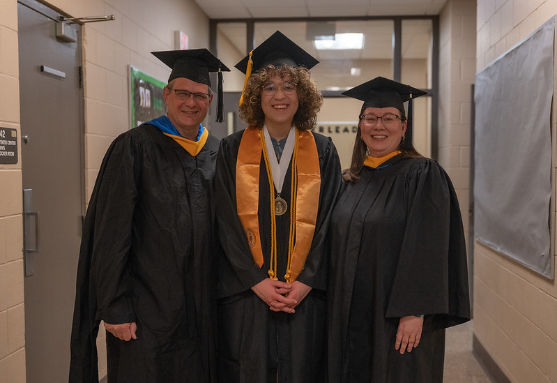 Candid graduation photo of three DACC students